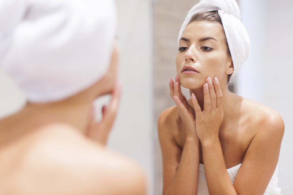 Woman looking on reflection in the mirror after shower